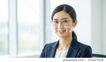 A portrait of a Japanese female employee with an intelligent gaze and glasses 134027830