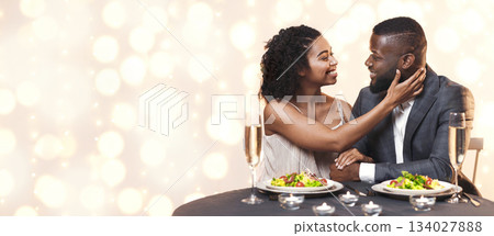 I love you. Attractive black woman touching her handsome man, cuddling in restaurant, having festive dinner together I love you. Attractive black woman touching her handsome man, cuddling in restaurant, having festive dinner together 134027888