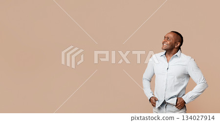 Great offer. Smiling mature afro american man looking at free space, orange background Great offer. Smiling mature afro american man looking at free space, orange background 134027914