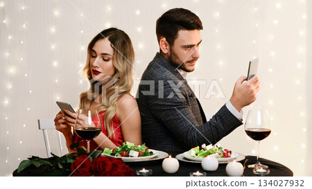 Date Fail. Bored Couple Using Smartphones Sitting Back To Back On Romantic Dinner In Restaurant, Ignoring Each Other. 134027932