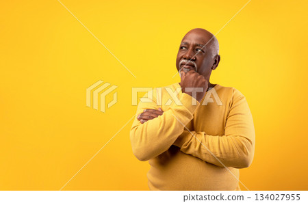 Thoughtful senior African American man looking aside at empty space, touching his chin, deep in thought on orange studio background. Dreamy elderly black male offering place for your advertisement Thoughtful senior African American man looking aside at empty space, touching his chin, deep in thought on orange studio background. Dreamy elderly black male offering place for your advertisement 134027955