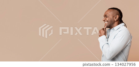 Cheerful mature african american man looking at empty space, orange background Cheerful mature african american man looking at empty space, orange background 134027956