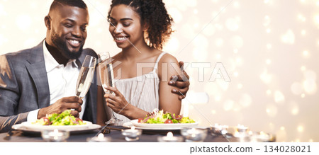 Young black couple toasting with champagne while having dinner at restaurant, close up Young black couple toasting with champagne while having dinner at restaurant, close up 134028021
