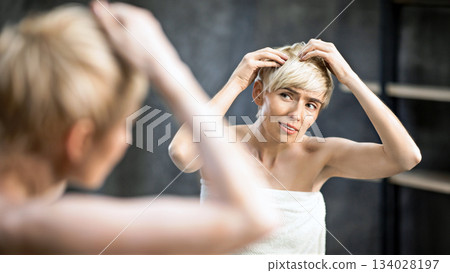 Lady Suffering From Dandruff Problem Touching Hair With Flakes Standing In Bathroom At Home. Selective Focus Lady Suffering From Dandruff Problem Touching Hair With Flakes Standing In Bathroom At Home. Selective Focus 134028197
