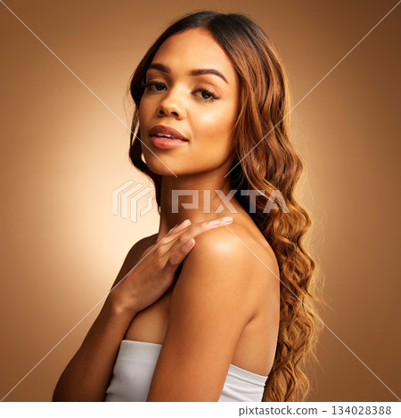 Hair care, beauty and woman in portrait, balayage and keratin treatment on brown background. Female, curly hairstyle and cosmetics, cosmetology in studio with makeup, glow and shine with satisfaction 134028388