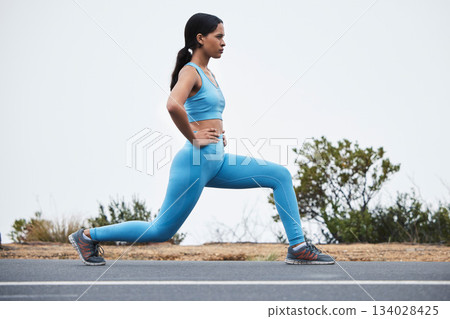 Legs stretching, woman profile and runner exercise on a outdoor road with concentration. Workout warm up, running training and wellness of a young female ready for sports and marathon run in mist 134028425