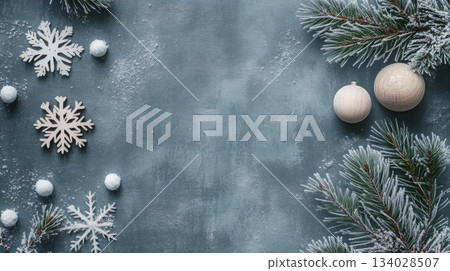 A delightful arrangement features snowflakes made of wood, white ornaments, and frosted pine branches on a textured gray surface, capturing the essence of winter's charm and holiday spirit. 134028507