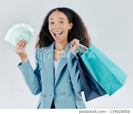 Happy woman, portrait and shopping bags with money winning sale or discount against white studio background. Excited and surprised female shopper smiling with cash, gift or profit in retail happiness Happy woman, portrait and shopping bags with money winning sale or discount against white studio background. Excited and surprised female shopper smiling with cash, gift or profit in retail happiness 134028688