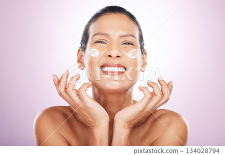 Face smile, cream and skincare of woman in studio isolated on a purple background. Mature, portrait and happy female model with dermatology lotion, creme and moisturizer cosmetics for healthy skin. 134028794