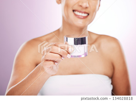 Hands, cream jar and woman smile in studio isolated on purple background. Face skincare, dermatology cosmetics and happy female holding lotion container, creme or moisturizer product for skin health. Hands, cream jar and woman smile in studio isolated on purple background. Face skincare, dermatology cosmetics and happy female holding lotion container, creme or moisturizer product for skin health. 134028818