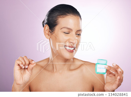 Face, smile and woman with dental floss for cleaning, hygiene or tooth care in studio isolated on a purple background. Oral health, cosmetics and happy mature female model flossing teeth for wellness Face, smile and woman with dental floss for cleaning, hygiene or tooth care in studio isolated on a purple background. Oral health, cosmetics and happy mature female model flossing teeth for wellness 134028841