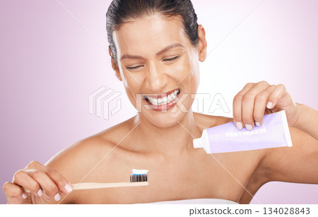 Smile, woman and bamboo toothbrush and toothpaste in studio isolated on a purple background. Eco friendly, cleaning and happy mature female brushing teeth with natural wooden brush for dental hygiene 134028843