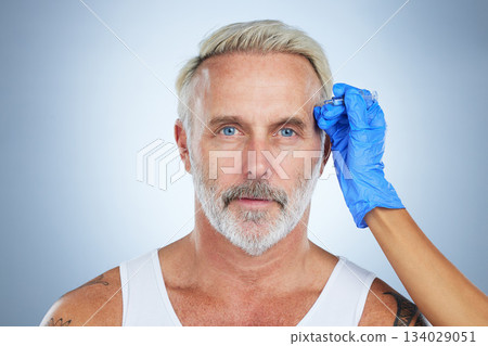 Syringe, facial and portrait of a senior man in a studio doing plastic surgery and cosmetic skincare. Dermatology, wrinkles and anti aging treatment of a mature model with silicone filler injection 134029051