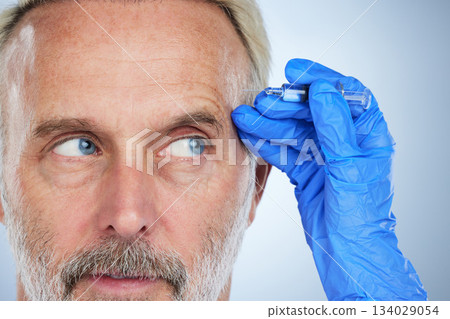Senior, face closeup and needle of a man in a studio doing plastic surgery and cosmetic skincare. Dermatology, wrinkles and anti aging treatment of a mature model with silicone filler injection 134029054