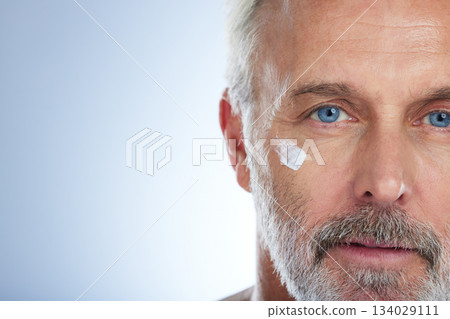 Senior man, cream and portrait, face with skincare and beauty, hygiene and grooming on studio background. Lotion, moisturizer and dermatology mockup, anti aging cosmetic care and serious male closeup 134029111