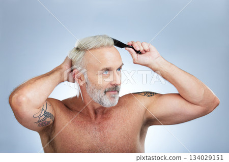 Mature man, brush hair and scalp health treatment in a studio with a model doing beauty routine. Wellness lifestyle, hairstyle care and male with hairdresser comb with an isolated grey background 134029151