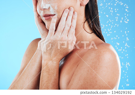 Woman face cleaning, shower water and studio with a young female hands doing skincare. Bathroom, dermatology beauty and facial treatment of a model hand with mock up and isolated blue background Woman face cleaning, shower water and studio with a young female hands doing skincare. Bathroom, dermatology beauty and facial treatment of a model hand with mock up and isolated blue background 134029192