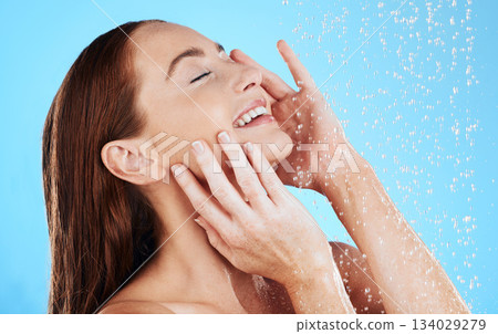 Shower, water and smile of woman in studio, blue background and cleaning for hygiene. Happy female model washing with wet drops for beauty, skincare and grooming for self care, wellness and routine Shower, water and smile of woman in studio, blue background and cleaning for hygiene. Happy female model washing with wet drops for beauty, skincare and grooming for self care, wellness and routine 134029279