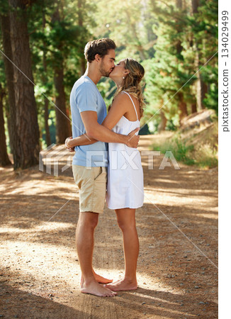 Couple kiss, love and hug in forest, summer with freedom and adventure, relationship with affection and care outdoor. People together in nature park, commitment and trust with romance and bonding Couple kiss, love and hug in forest, summer with freedom and adventure, relationship with affection and care outdoor. People together in nature park, commitment and trust with romance and bonding 134029499