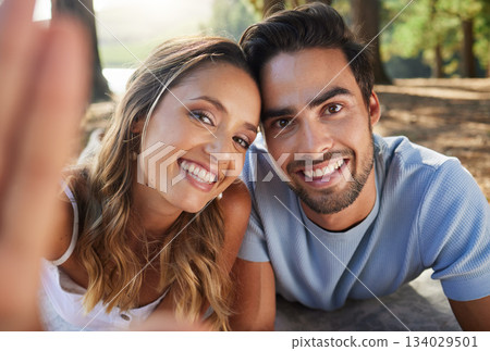 Selfie, happy and portrait of a couple in nature for a memory, date and bonding. Smile, looking and a young man and woman taking a photo in the woods or forest for relationship memories together 134029501