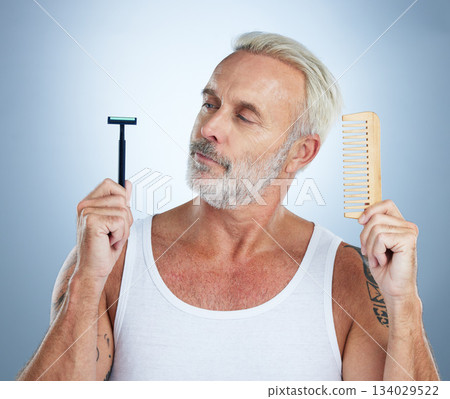 Senior man, shaver and comb thinking for grooming, skincare or hair removal against studio background. thoughtful mature male holding razor blade and brush for haircare, cosmetics or facial treatment Senior man, shaver and comb thinking for grooming, skincare or hair removal against studio background. thoughtful mature male holding razor blade and brush for haircare, cosmetics or facial treatment 134029522