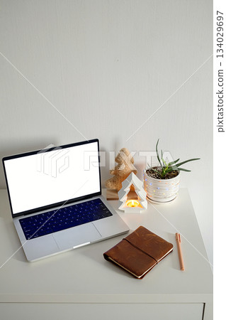 Laptop with blank screen on desk with festive Christmas decor. Laptop with blank screen on desk with festive Christmas decor. 134029697