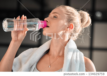 Fitness, athlete and woman drinking water in gym after workout, training or exercise. Sports, nutrition and thirsty athletic female drink liquid aqua from bottle for hydration, health and wellness 134029759
