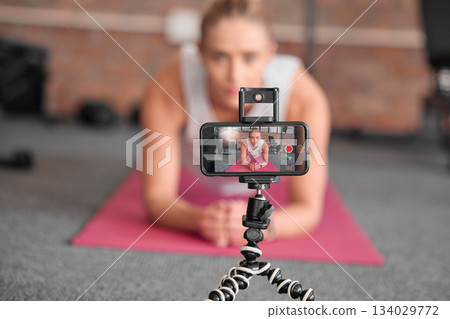 Live streaming, fitness and phone of woman exercise, pilates or workout on social media or video platform on tripod. Gen z athlete, sports influencer or content creator training on smartphone screen 134029772