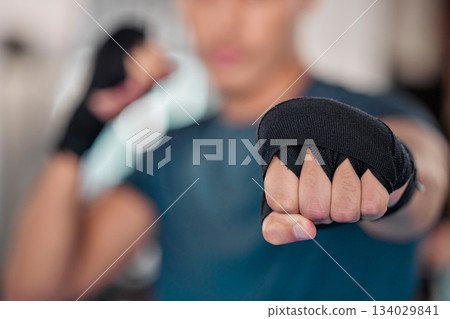 Man, fist and boxing, fitness and martial arts in gym, exercise and power, strong person and punch. Workout, male boxer training in combat and sports, athlete ready to fight and mma fighter hand zoom Man, fist and boxing, fitness and martial arts in gym, exercise and power, strong person and punch. Workout, male boxer training in combat and sports, athlete ready to fight and mma fighter hand zoom 134029841