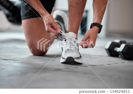 Fitness, hands and tie shoes in gym to start workout, training or exercise. Sports, athlete and man tying footwear or sneakers to get ready or prepare for running, cardio or exercising for health. Fitness, hands and tie shoes in gym to start workout, training or exercise. Sports, athlete and man tying footwear or sneakers to get ready or prepare for running, cardio or exercising for health. 134029851