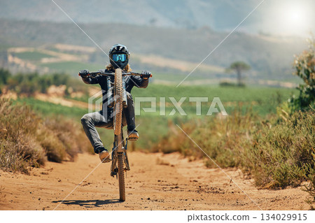 Cycling, fitness and person on a bicycle in the countryside for extreme sport, adrenaline and fun. Speed, action and cyclist on a dirt road for stunt, trick or training, freedom and balance in nature Cycling, fitness and person on a bicycle in the countryside for extreme sport, adrenaline and fun. Speed, action and cyclist on a dirt road for stunt, trick or training, freedom and balance in nature 134029915