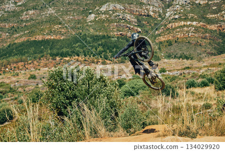 Jump, extreme sports and mountain bike with man in nature for cycling, fitness and adventure. Adrenaline junkie, performance and stunt with athlete riding in outdoors for action, risk and training 134029920