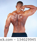Black man, neck pain and injury with exercise and health, medical problem and aching body with back view. Emergency, muscle tension and male athlete with joint ache from workout on blue background 134029945