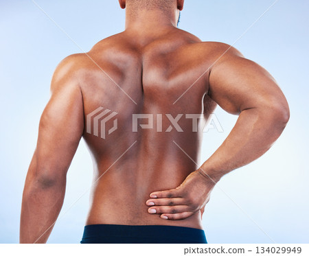 Black man, back pain and injury with fitness and health, medical problem and aching body in studio. Emergency, muscle tension and male athlete with joint ache from workout on blue background Black man, back pain and injury with fitness and health, medical problem and aching body in studio. Emergency, muscle tension and male athlete with joint ache from workout on blue background 134029949