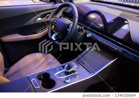 Closeup of a modern car steering wheel with control buttons for technology and convenience 134030004