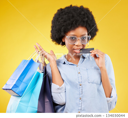Shopping bag, retail credit card and portrait black woman with sales product, studio fashion deal or mall store attitude. Commerce market, discount gift or female customer biting on yellow background Shopping bag, retail credit card and portrait black woman with sales product, studio fashion deal or mall store attitude. Commerce market, discount gift or female customer biting on yellow background 134030044