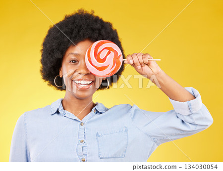 Cover, candy and lollipop with black woman in studio for colorful, cheerful and positive. Young, happiness and dessert with female isolated on yellow background for treats, food and confectionary Cover, candy and lollipop with black woman in studio for colorful, cheerful and positive. Young, happiness and dessert with female isolated on yellow background for treats, food and confectionary 134030054