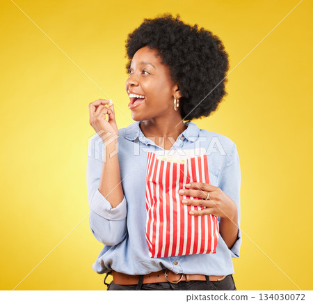 Happy, eating and popcorn with black woman in studio for movie, streaming service and cinema. Television, smile and theatre with female and snack isolated on yellow background for food, tv and film Happy, eating and popcorn with black woman in studio for movie, streaming service and cinema. Television, smile and theatre with female and snack isolated on yellow background for food, tv and film 134030072