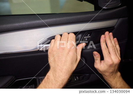 Mechanic fixing vehicle door parts, Closeup of technician repairing car interior components, Professional worker servicing vehicle door with detailed focus and tools Mechanic fixing vehicle door parts, Closeup of technician repairing car interior components, Professional worker servicing vehicle door with detailed focus and tools 134030094