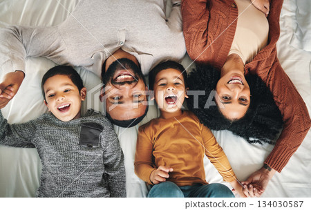 Laughing, family and top view portrait on bed in bedroom, bonding and care in home. Love, smile and happy mother, comic father and funny children playing, having fun and enjoying joke time together. 134030587