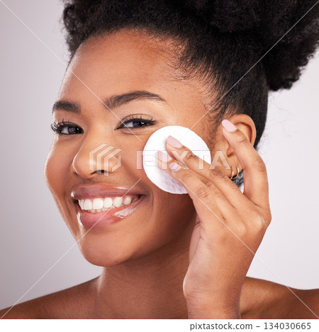 Black woman, cotton and skincare in studio with smile in headshot, cleaning or makeup removal by background. Young model, wipe and clean for natural glow, wellness and cosmetic beauty for self care 134030665