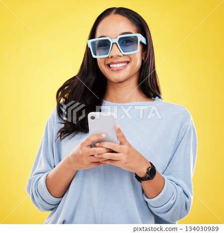 Phone, smile and portrait of woman with sunglasses in yellow studio for social media, website and internet. Communication, mockup space and happy girl on smartphone for chat, message and network Phone, smile and portrait of woman with sunglasses in yellow studio for social media, website and internet. Communication, mockup space and happy girl on smartphone for chat, message and network 134030989