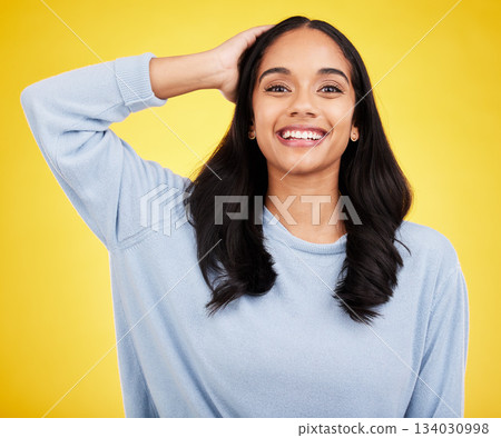 Young woman, hair and beauty, happy in portrait and satisfaction with gen z, fashion on yellow studio background. Happiness, youth and Indian female smile, haircare and cosmetics, growth and shine 134030998