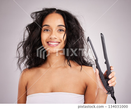 Portrait, happy woman and hair straightener for beauty in studio, transformation or smile on background. Female model, haircare and heat styling equipment of ironing curly hairstyle, texture or tools 134031000