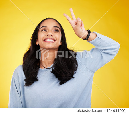 Happy, woman and thinking of peace fingers in studio, background and color backdrop. Female model, v sign and smile with hands for victory, fun mood and happiness of gen z, vote and freedom of emoji Happy, woman and thinking of peace fingers in studio, background and color backdrop. Female model, v sign and smile with hands for victory, fun mood and happiness of gen z, vote and freedom of emoji 134031001