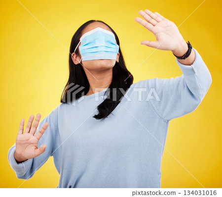 Face mask, covid and woman in blindfold in studio for medical misinformation or conspiracy theory. Deception, virus and female isolated on yellow background for vaccine, protection or pandemic safety Face mask, covid and woman in blindfold in studio for medical misinformation or conspiracy theory. Deception, virus and female isolated on yellow background for vaccine, protection or pandemic safety 134031016