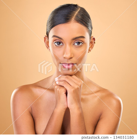Face, beauty and portrait of woman in studio for skincare, cosmetics, dermatology or makeup. Aesthetic female .serious about self care, natural skin and spa facial shine results on a brown background Face, beauty and portrait of woman in studio for skincare, cosmetics, dermatology or makeup. Aesthetic female .serious about self care, natural skin and spa facial shine results on a brown background 134031180