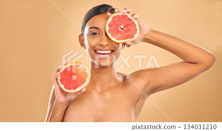 Indian woman, grapefruit and beauty with face in portrait, natural cosmetics and organic treatment on studio background. Skincare, healthy glow and female smile with fruit product, skin and mockup 134031210