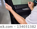 Mechanic fixing vehicle door parts, Closeup of technician repairing car interior components, Professional worker servicing vehicle door with detailed focus and tools 134031382