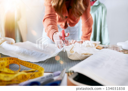 Fashion, designer and cutting fabric in workshop, woman working with scissors for dress making and manufacturing clothes. Clothing, designer and measuring tape with textile business and creative. 134031838